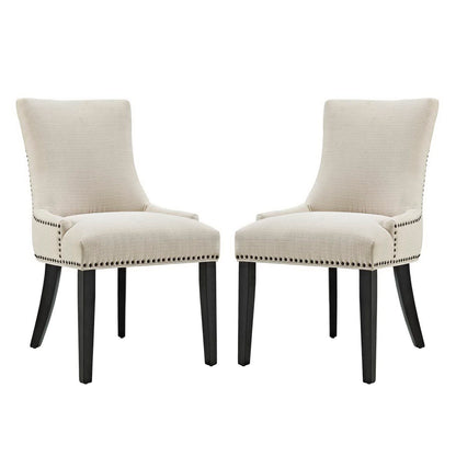 Pair of beige upholstered dining chairs with dark wood legs, curved backs, and nailhead trim.