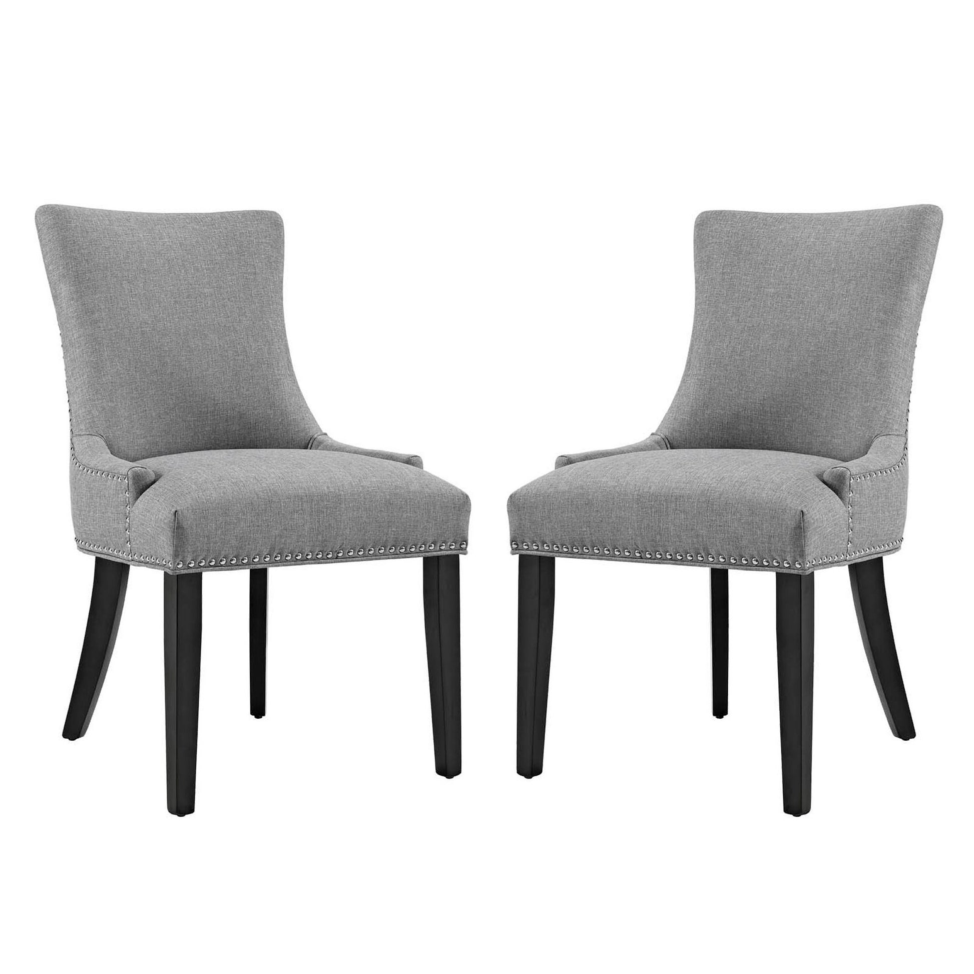 Pair of grey upholstered dining side chairs with curved backs, nailhead trim, and dark wood legs.