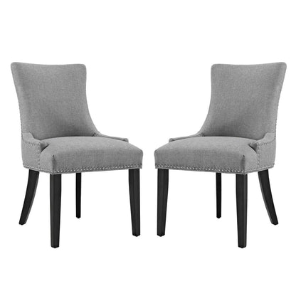 Pair of grey upholstered dining side chairs with curved backs, nailhead trim, and dark wood legs.