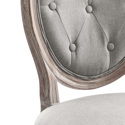 Light gray tufted fabric dining side chair with a curved wooden frame and button detailing.