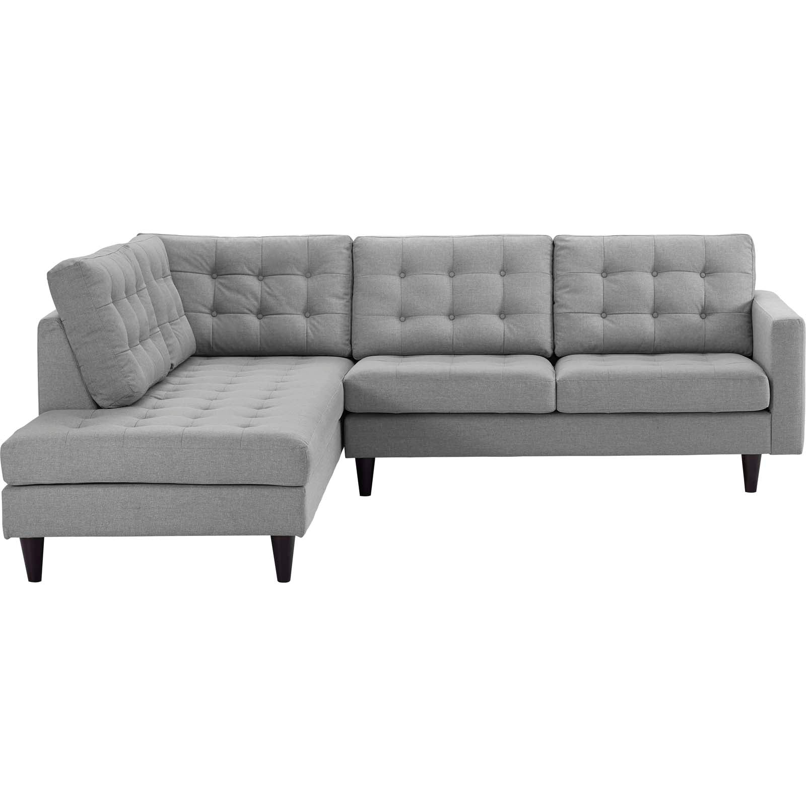 Light gray fabric L-shaped sectional sofa with tufted back cushions and a left chaise, tapered dark wood legs.