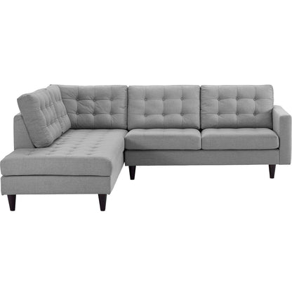 Light gray fabric L-shaped sectional sofa with tufted back cushions and a left chaise, tapered dark wood legs.