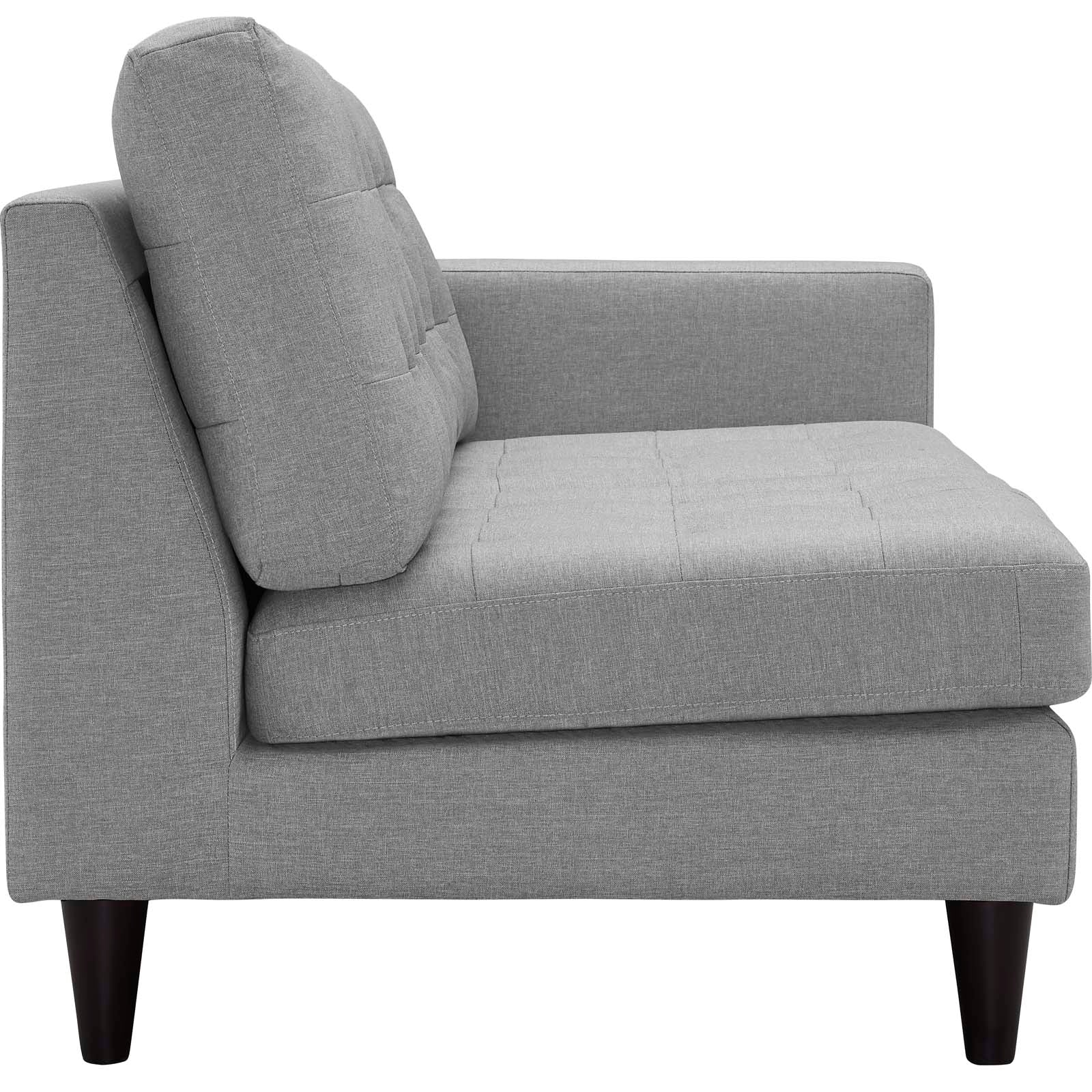 Light gray fabric left-facing bumper sectional with tufted seats, tall back cushions, and tapered dark wood legs.