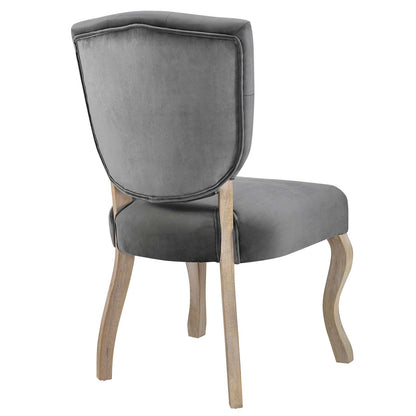 Grey velvet upholstered dining chair with curved light-wood legs and cushioned back and seat.