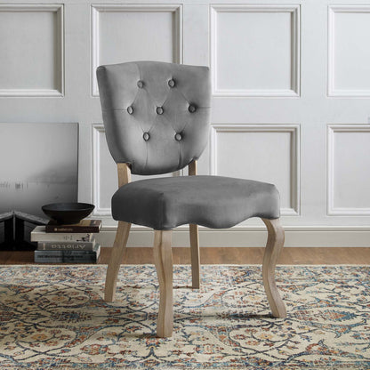 Gray velvet tufted dining chair with diamond buttons and curved light wood legs.