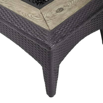 Dark brown woven outdoor wicker rectangular fire pit table with a light wood-look top and built-in fire pit.