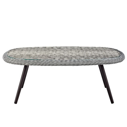 Oval gray wicker rattan coffee table with glass inset and dark angled legs