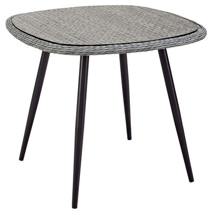 Gray outdoor dining table with a woven wicker top and four black tapered legs; 36 inches.