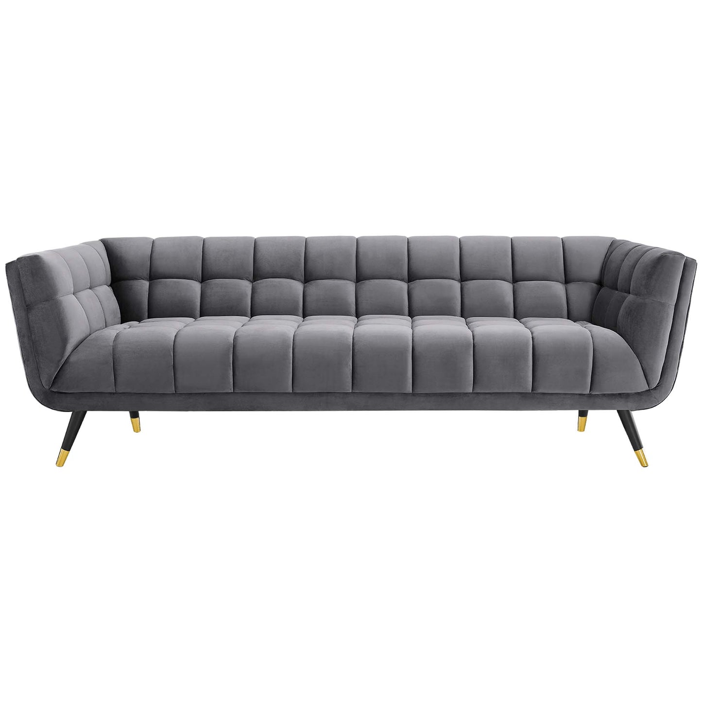 Gray velvet tufted sofa with grid cushions, low curved arms, angled legs with gold tips, modern mid-century style.