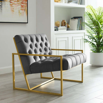 Gray performance velvet accent chair with a gold stainless steel frame and angular arms in a bright modern living room.