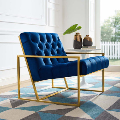 Navy blue tufted velvet accent chair with a gold stainless steel frame in a living room with a round white table.