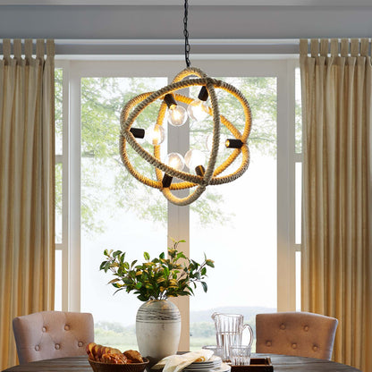 Natural rope pendant chandelier with exposed bulbs hangs over a wood dining table with tufted beige chairs and a greenery vase.