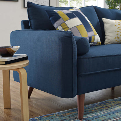 Navy blue fabric loveseat with geometric yellow-gray cushions, tapered wooden legs, beside a light wood side table.