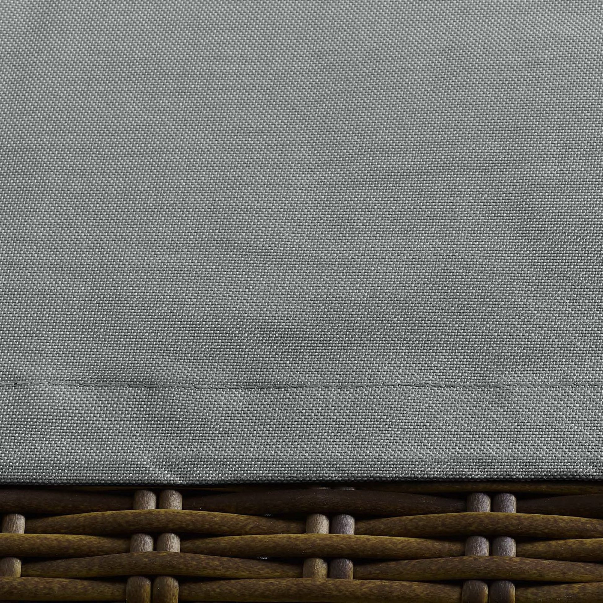 Gray textured fabric lid atop brown woven rattan base; outdoor patio furniture cover.