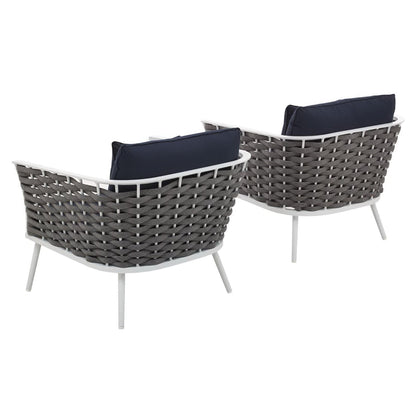 Two white aluminum outdoor armchairs with navy cushions.