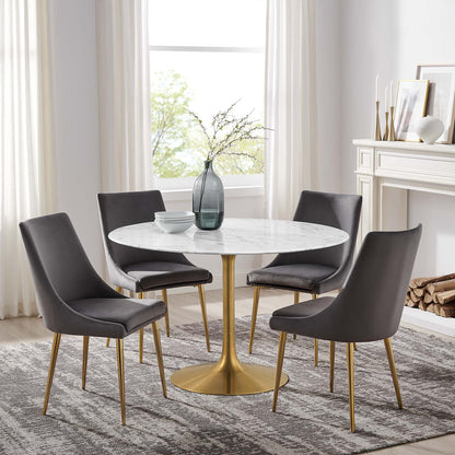 Round faux-marble dining table with a brass pedestal; modern white table.