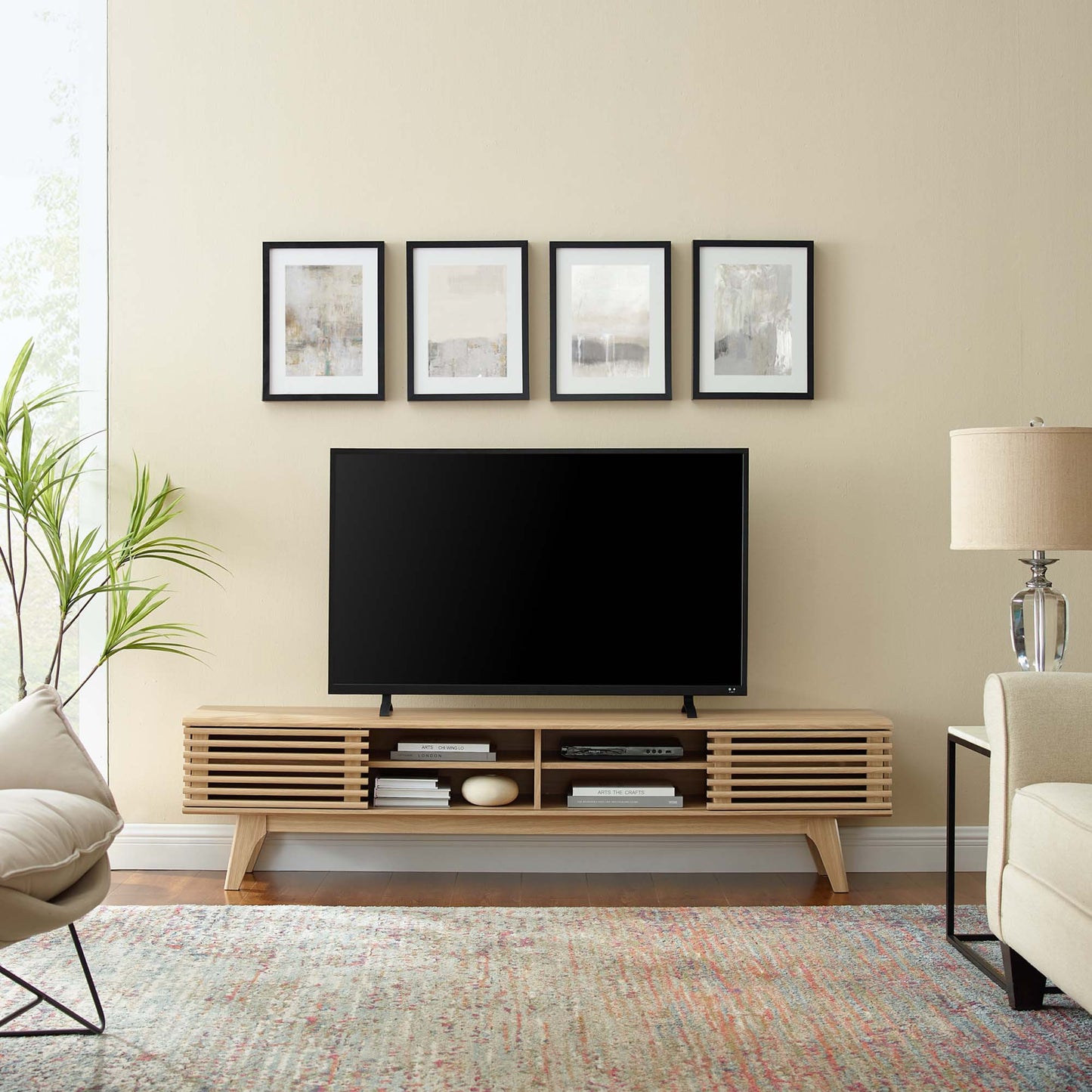 Oak entertainment center TV stand with slatted doors and open shelves, supporting a flat-screen TV; framed art above in a beige living room.