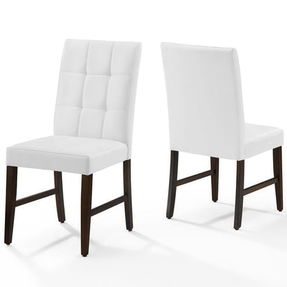 Pair of white faux-leather dining side chairs with biscuit tufted backs and dark brown wooden legs.