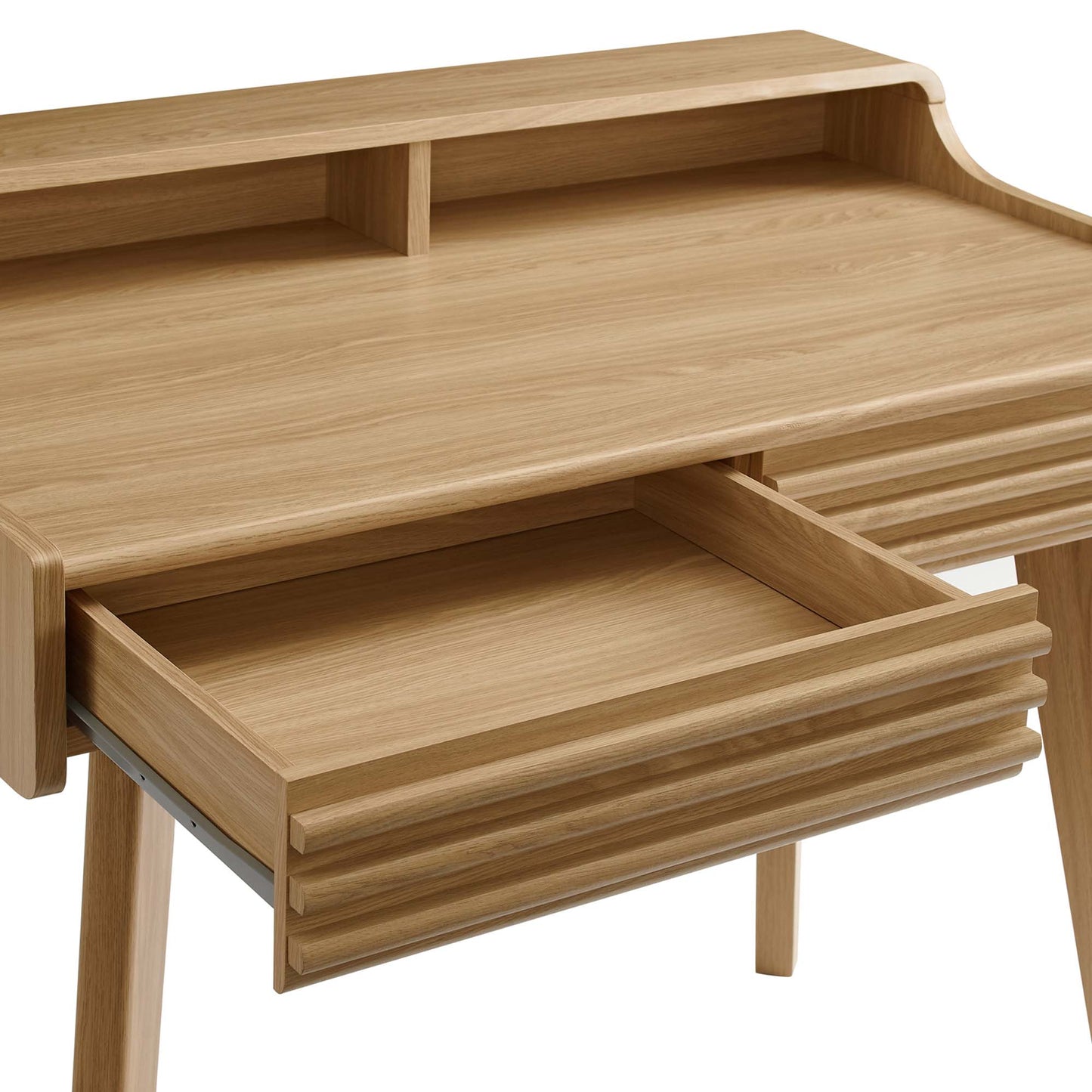 Oak wood desk with a raised back shelf, two small compartments, and a ribbed pull-out drawer in a mid-century style.