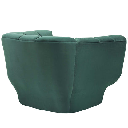 Green velvet armchair with vertical-channel tufting and a rounded silhouette.