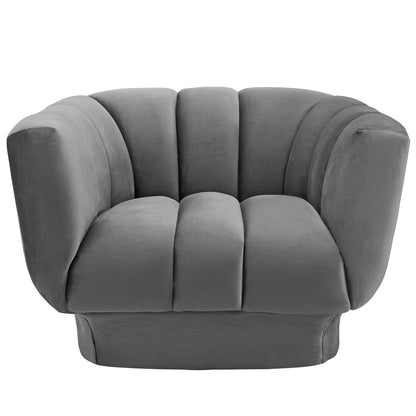 Gray velvet-style barrel chair with plush segmented cushions and rounded armrests.