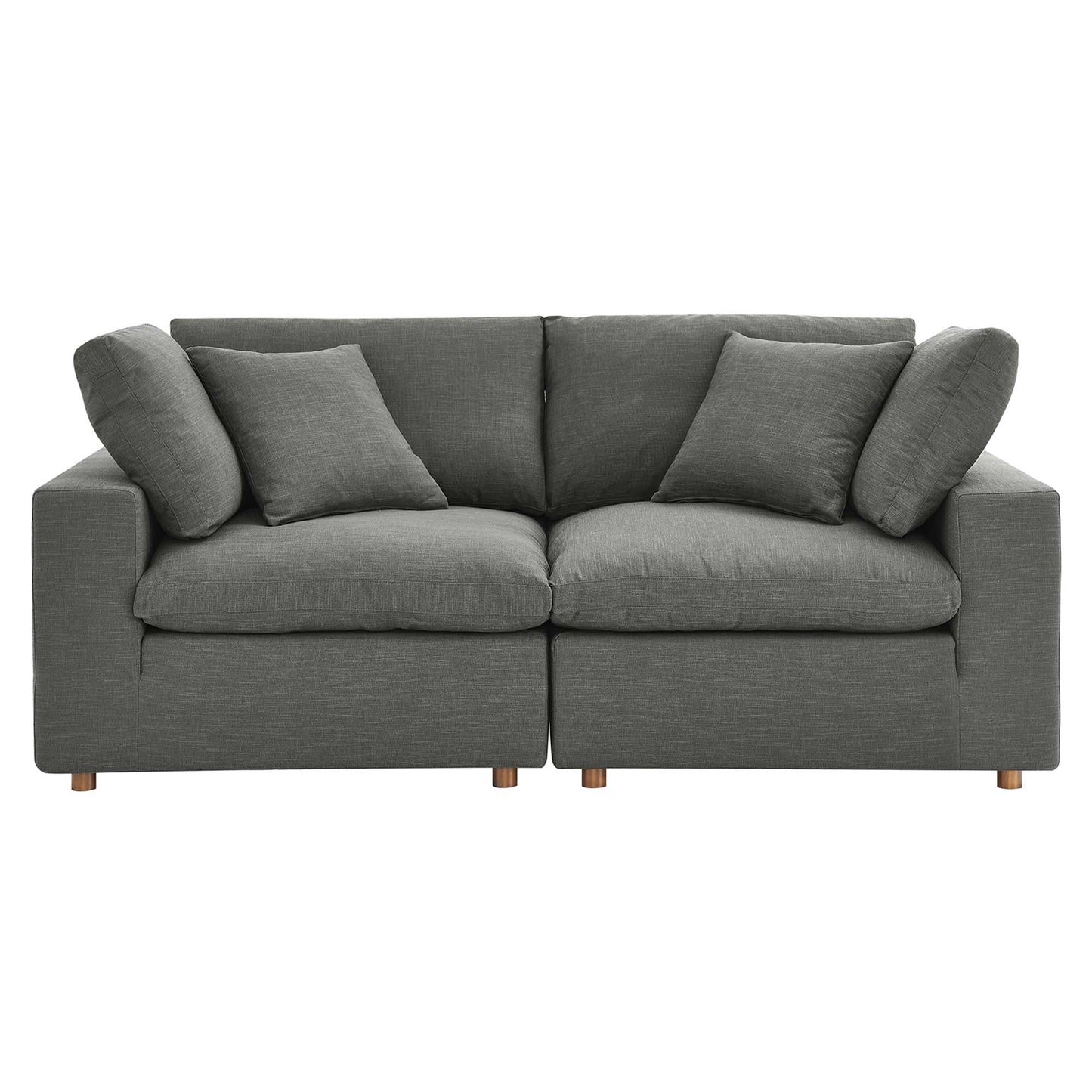 Grey fabric sofa with two-seat sections, multiple cushions and short wooden legs; modern living room centerpiece.