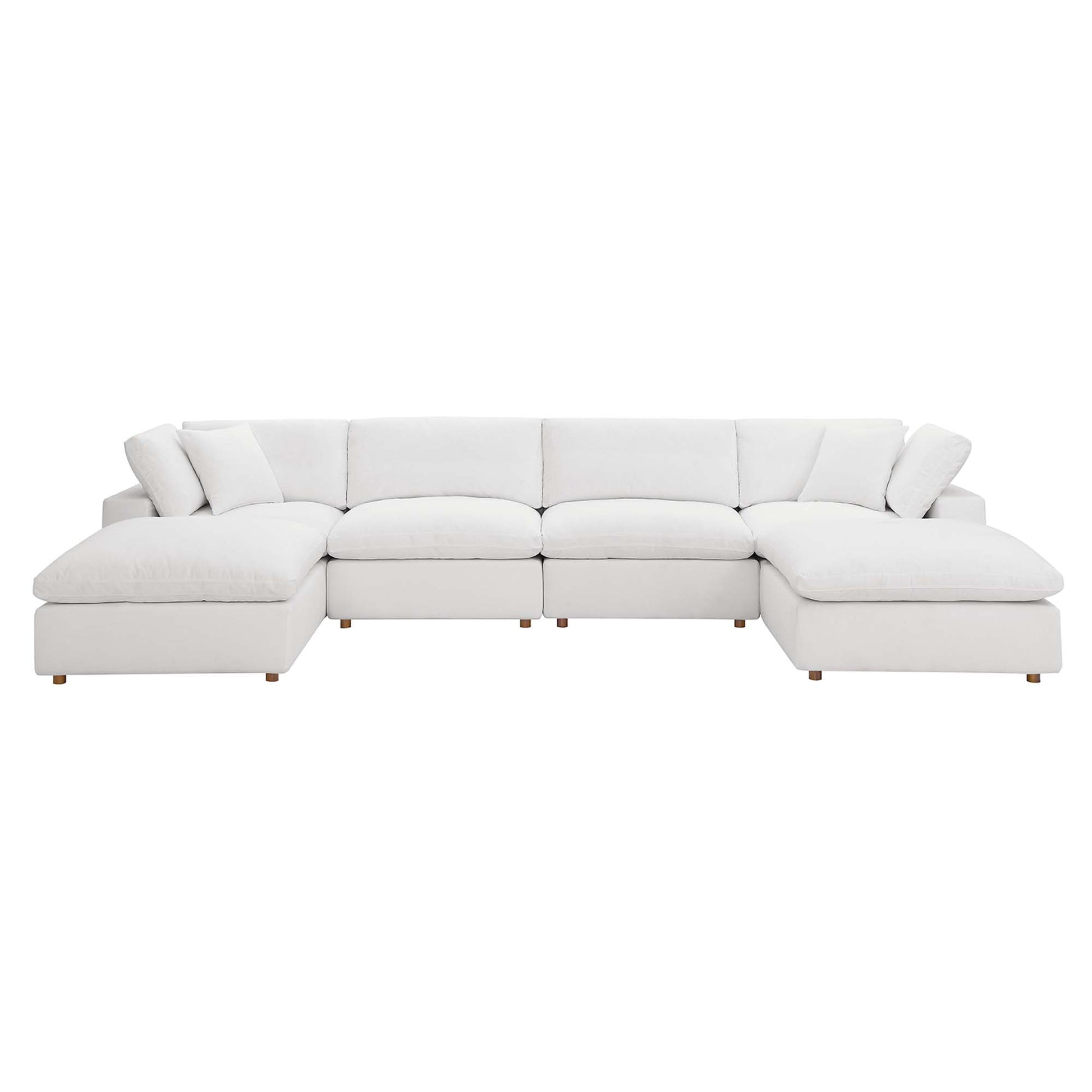 White fabric sectional sofa with chaise on both ends, plush cushions, and short wooden legs.