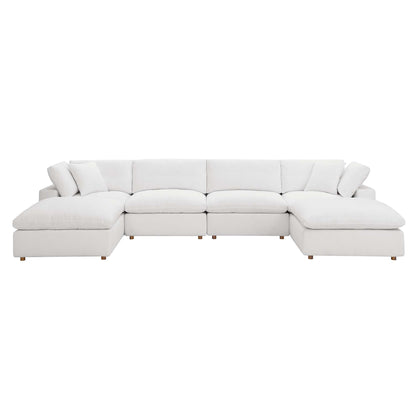 White fabric sectional sofa with chaise on both ends, plush cushions, and short wooden legs.