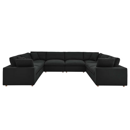 Large black fabric sectional sofa, L-shaped with thick cushions and wooden legs; modern modular living room seating.