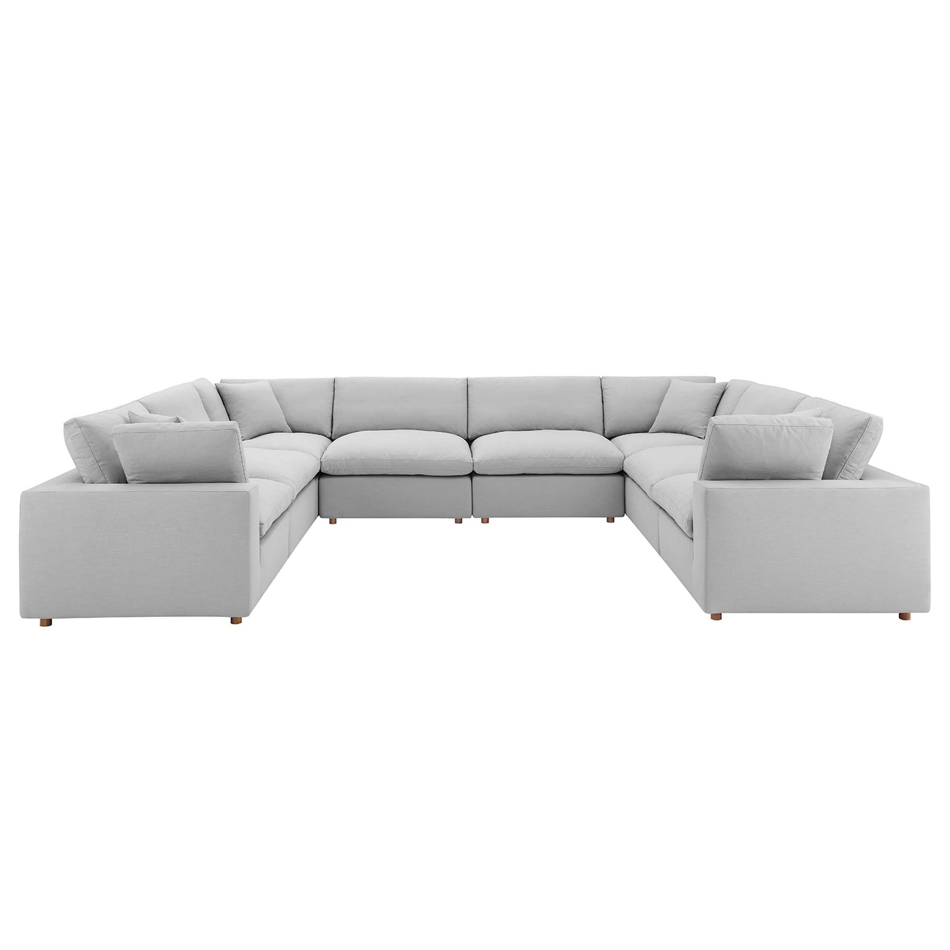 Light gray fabric sectional sofa in an L-shape with plush back cushions and low wooden legs.
