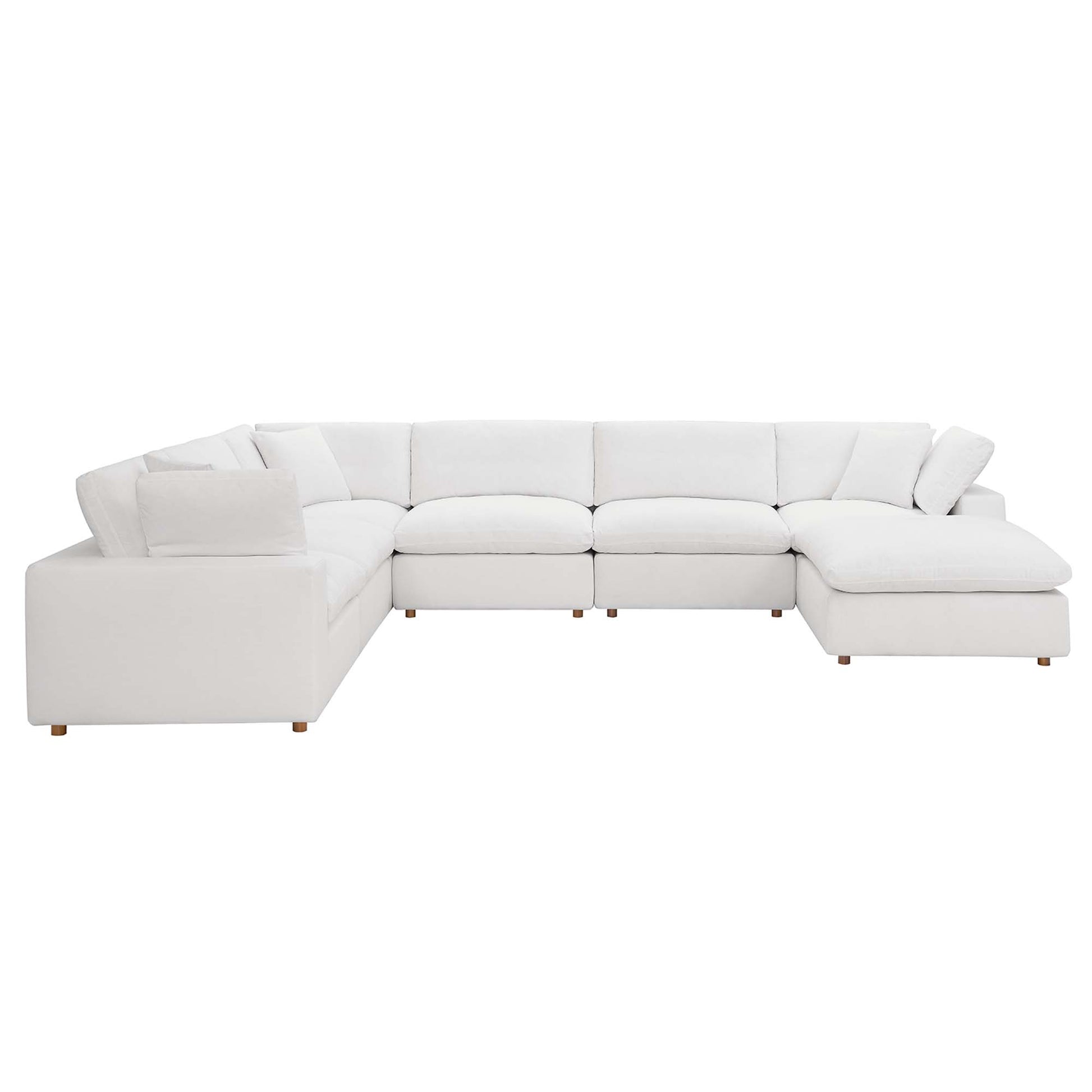 White fabric sectional sofa with chaise on the right, modular cushions and low wooden legs.