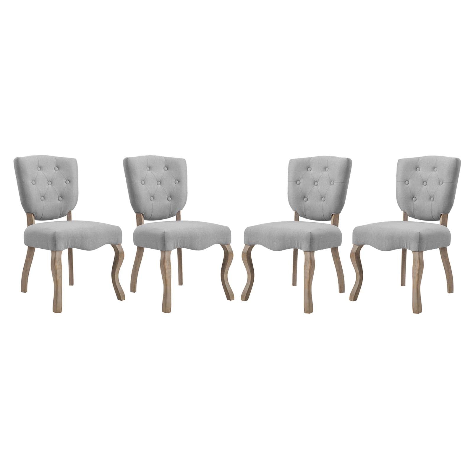 Set of four gray tufted fabric dining chairs with curved natural wood legs and button-back upholstery.