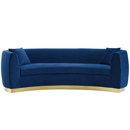 Navy blue velvet curved sofa with rounded arms, thick cushions and a gold metal base.