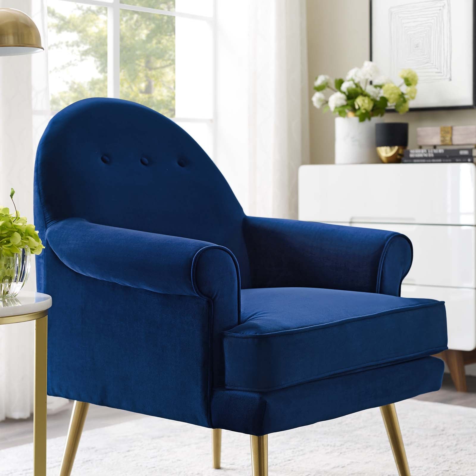 Navy blue velvet armchair with curved back, button-tufted, plush cushions, and gold legs for modern living room seating.