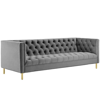 Gray velvet sofa with button-tufted back and seat, gold legs, modern mid-century living room seating.