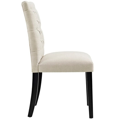Beige upholstered dining chair with padded back and black wooden legs.