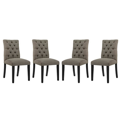 Four taupe tufted dining chairs with dark wooden legs and upholstered seats.