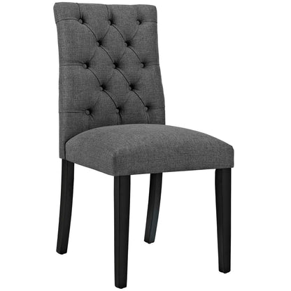 Gray upholstered dining chair with tufted back, cushioned seat, and black tapered legs.