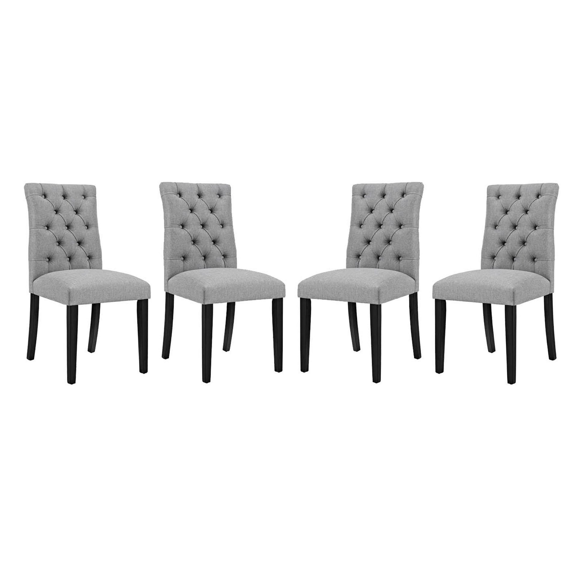 Four gray tufted fabric dining chairs with dark wood legs.