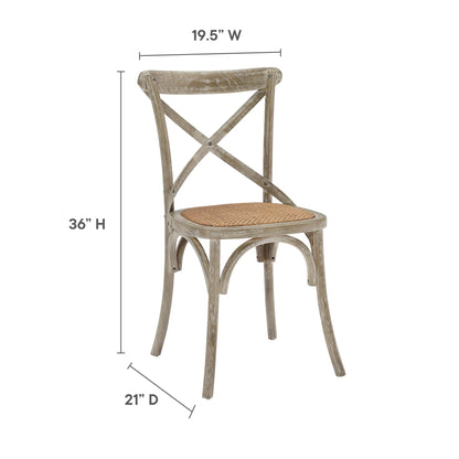 Rustic gray-washed wooden dining chair with cross-back X design and woven cane seat.