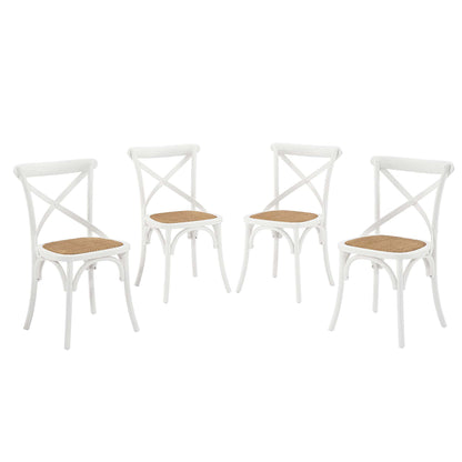 Set of four white wooden dining chairs with cross-back design and cane seats.