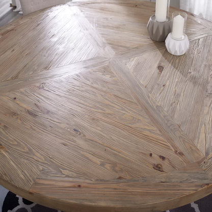 Round pine wood dining table with a warm brown finish and visible knots; two geometric ceramic candle holders with white candles.