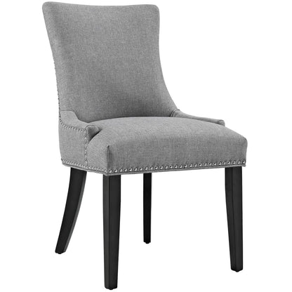 Grey upholstered dining chair with nailhead trim, tall curved back, padded arms, & dark wood legs.