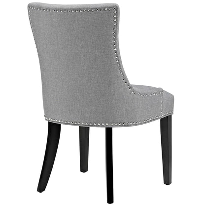 Gray fabric dining chair with nailhead trim along edges, curved back, and dark brown wooden legs.