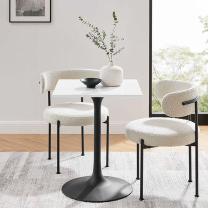 White 24-inch square wood dining table with two cream boucle chairs; vase and bowl on top