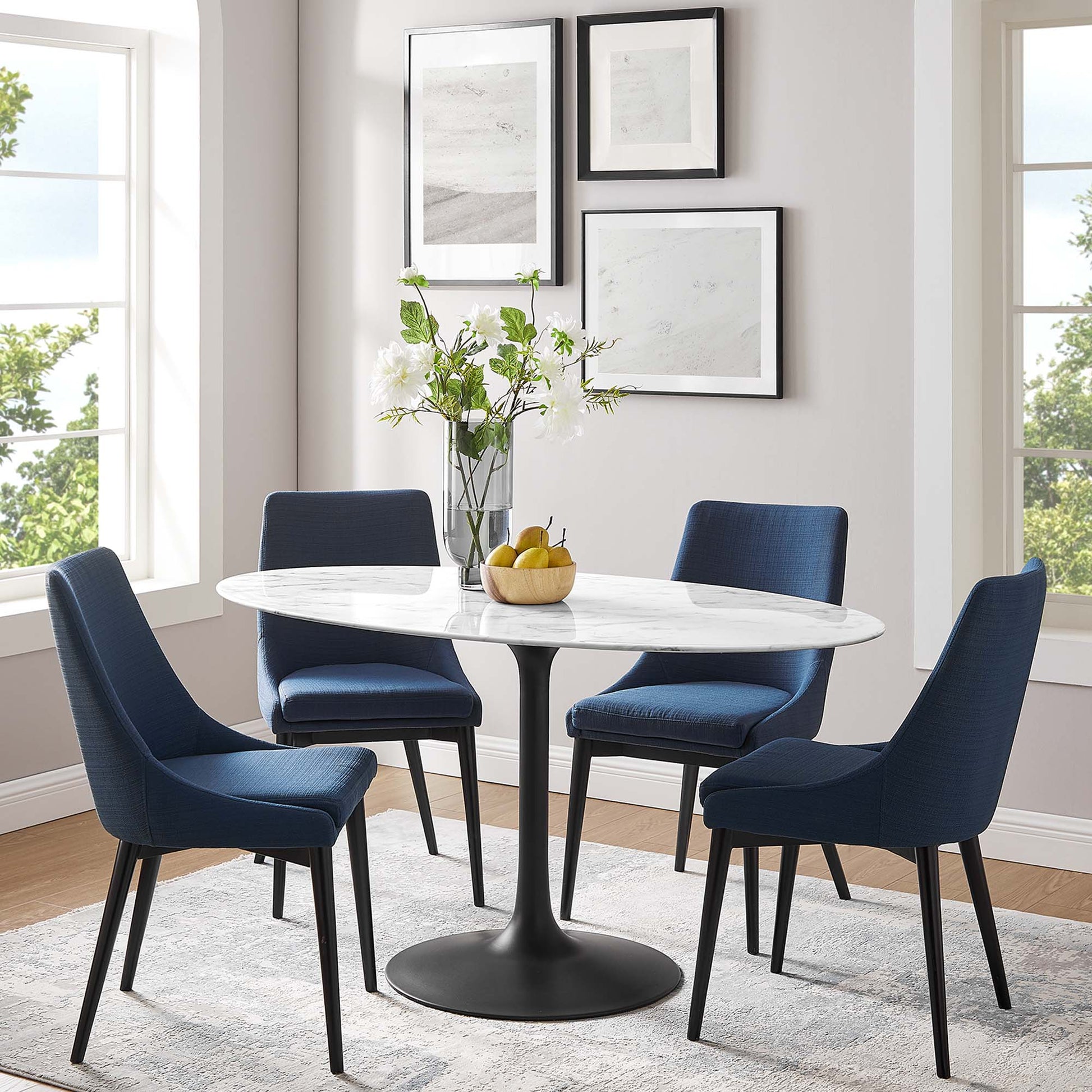 Oval faux marble dining table with pedestal base in white, in a modern dining room.