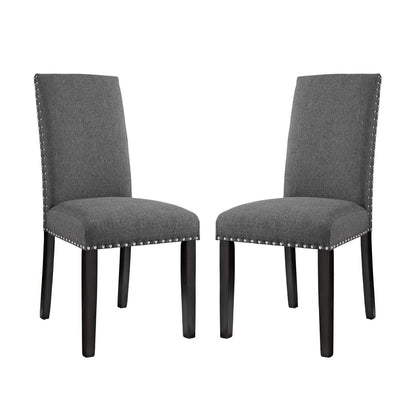 Pair of gray upholstered dining chairs with tall backs, dark wood legs, and silver nailhead trim.