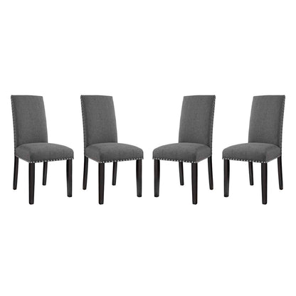 Set of four grey upholstered dining chairs with nailhead trim & dark wood legs.
