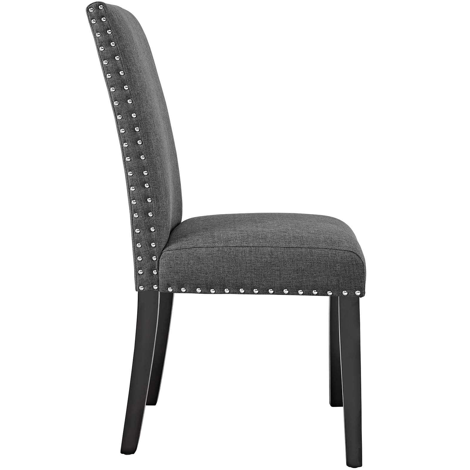 Gray fabric dining chair with nailhead trim along edges, padded back and seat, dark wooden tapered legs.