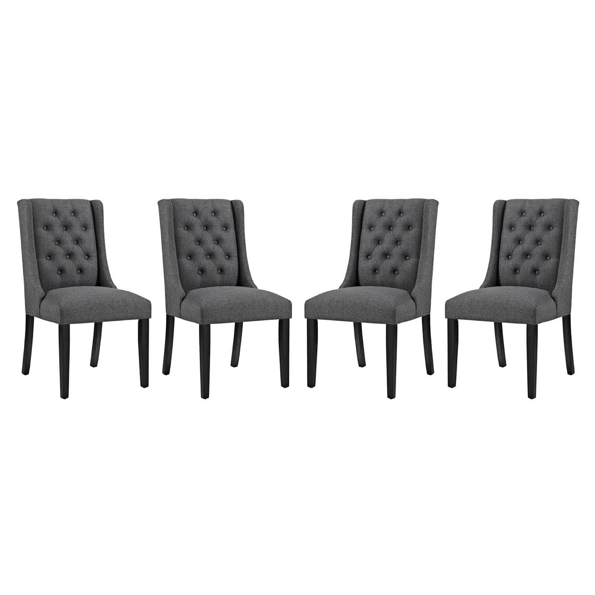 Set of four gray tufted dining chairs with fabric upholstery and tapered black legs.